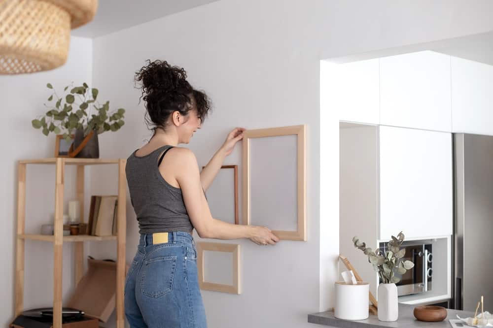 woman hanging photo frames