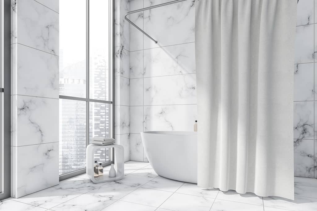 oval white ceramic bathtub with a curtain