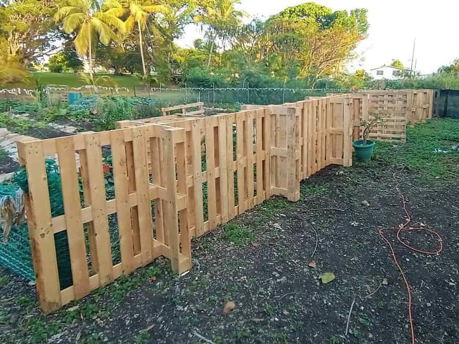 A wooden fence is being built in a garden.