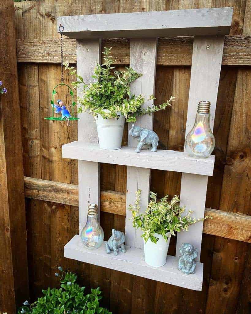 A wooden pallet shelf with potted plants on it.