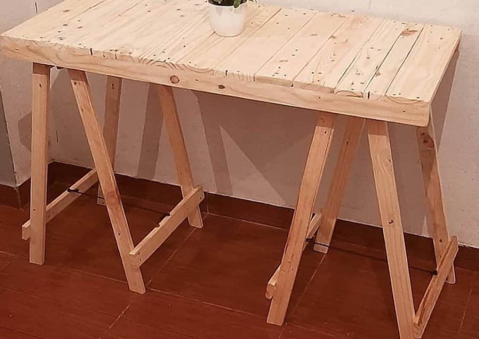 A wooden table with a potted plant on it.