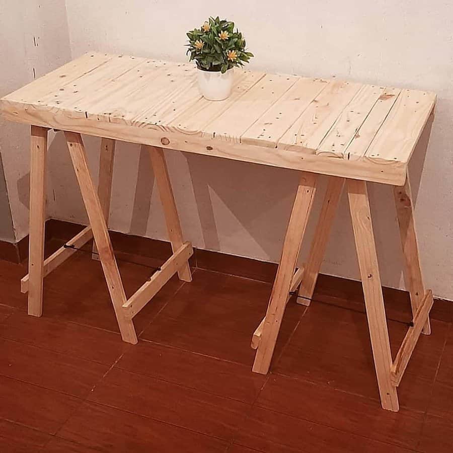 A wooden table with a potted plant on it.