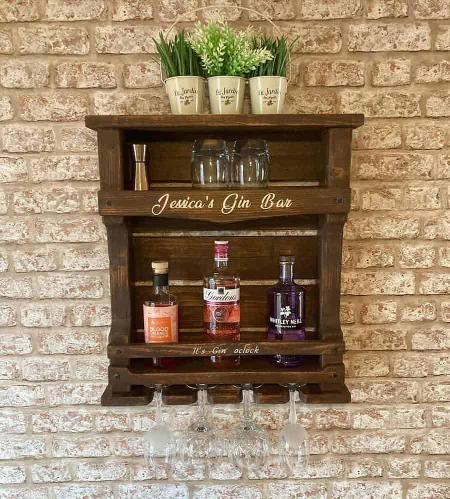 A wooden bar shelf with bottles and glasses on it.